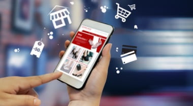 Eコマース（通信販売）を表現した画像。スマートフォンとショッピングアイコンが浮かぶ